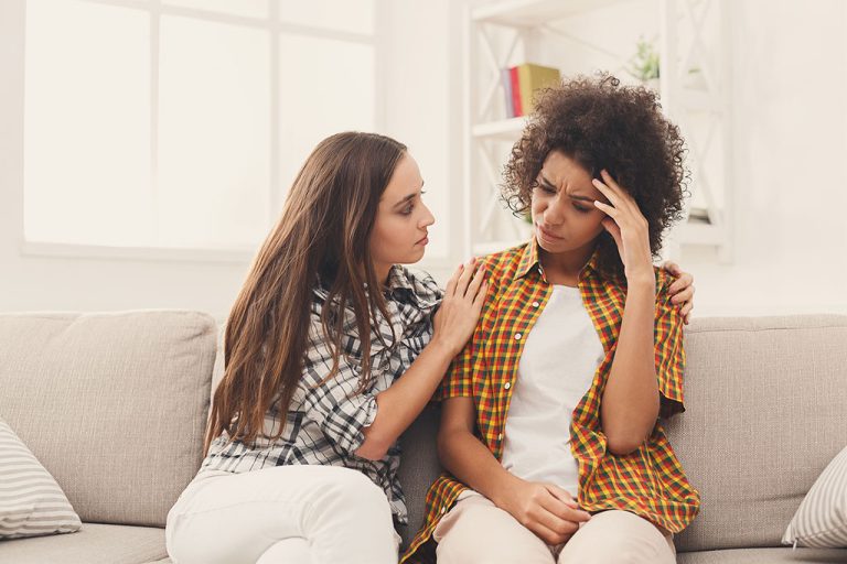 A Frustrated Woman Sitting on a Couch Being Consoled by Her Friend Abortion Advice From a Friend