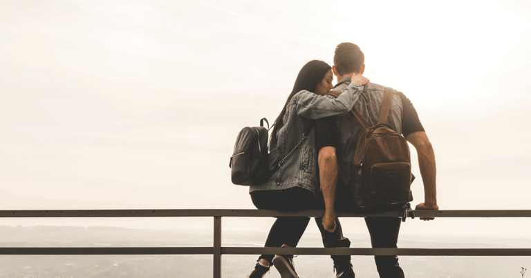 Young woman embracing her partner while considering whether to tell him she wants an abortion.