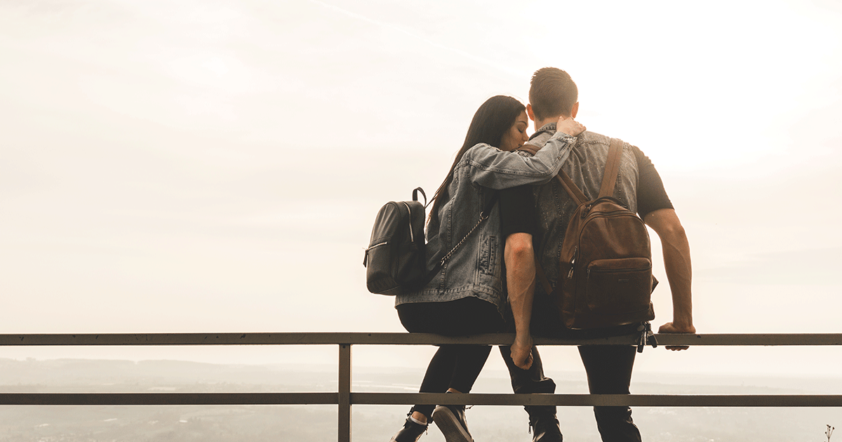 Young woman embracing her partner while considering whether to tell him she wants an abortion.