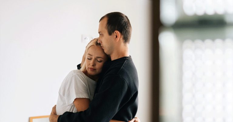 A man comforts his partner as she heals emotionally after an abortion.